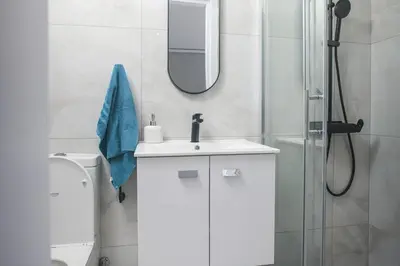 a white bathroom with a sink and a mirror at Elegant penthouse in City Centre in Larnaka