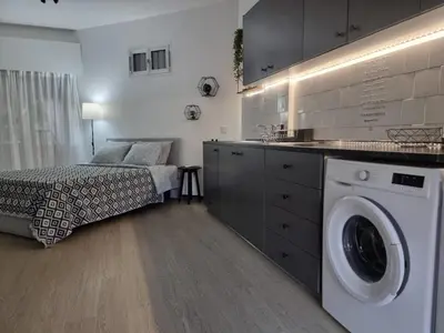 a bedroom with a bed and a washing machine at Paradise Garden Sweet Studio in Limassol