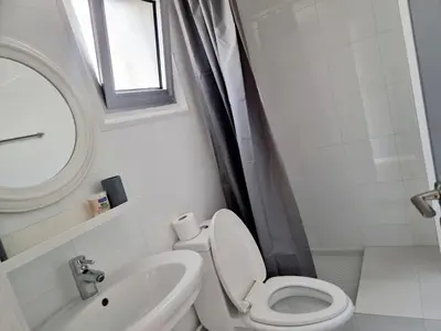 a bathroom with a toilet and a sink and a window at Paradise Garden Sweet Studio in Limassol