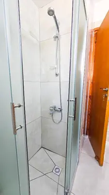 a shower with a glass door in a bathroom at Central City Rooms in Larnaka