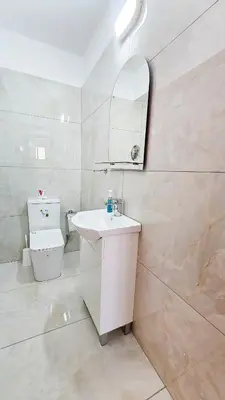 a white bathroom with a sink and a toilet at Central City Rooms in Larnaka