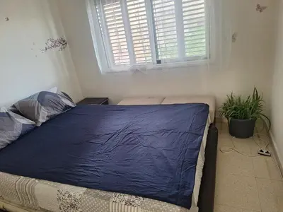a bedroom with a bed with a blue blanket on it at Easy 2 bedroom apartment, Makenzi beach in Larnaka