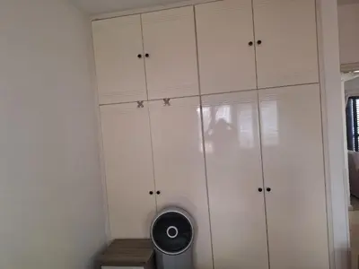 a closet with white cabinets and a fan at Easy 2 bedroom apartment, Makenzi beach in Larnaka