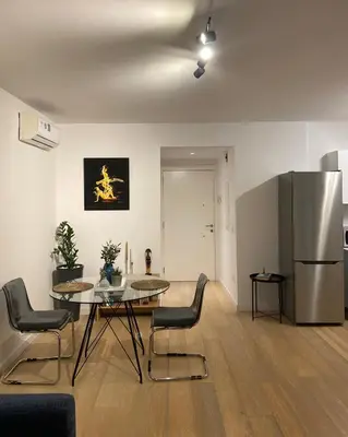 a living room with a table and a refrigerator at Stylish Apt near UNIC Medical School & EUC in Engomi