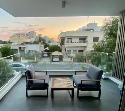two chairs and a coffee table on a balcony with a view at Stylish Apt near UNIC Medical School & EUC in Engomi