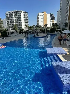a large swimming pool with blue water in a city at Marcellus in Larnaka