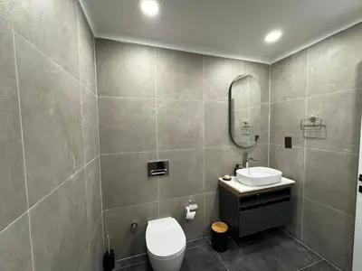 a bathroom with a sink and a toilet and a mirror at Kervansaray Comfort in Ayii Trimithias