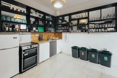 a kitchen with white appliances and black cabinets at One Love One World Ayia Napa Square Hostel in Ayia Napa
