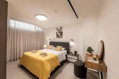 a bedroom with a large bed with a yellow blanket at Villa JoJo Seafront in Ayia Napa