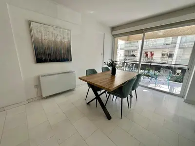 a dining room with a wooden table and chairs at 2 bedrooms flat near center in Engomi