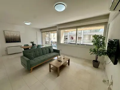 a living room with a green couch and a table at 2 bedrooms flat near center in Engomi