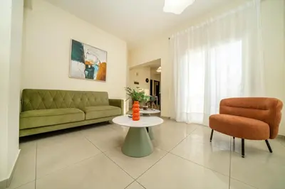 a living room with a couch and a table and a chair at 2 bedroom flat in Nicosia