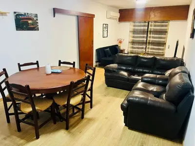 a living room with a table and a leather couch at Tiffany 11 Finikoudes in Larnaka