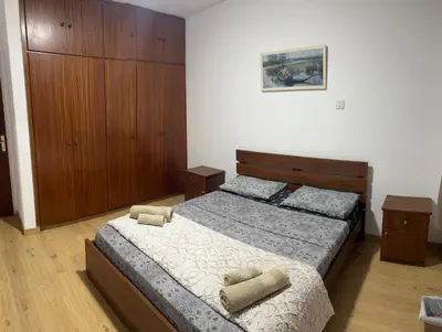 a bedroom with a bed and a wooden cabinet at Tiffany 11 Finikoudes in Larnaka