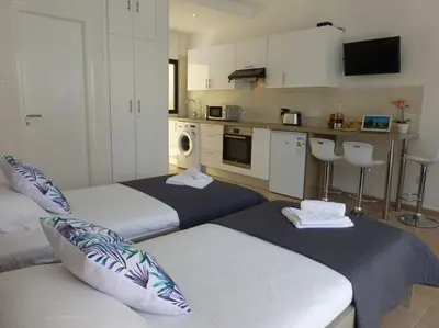two beds in a room with a kitchen at STAY Paradise Sands Studio in Ayia Napa