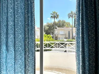 a view from a window with blue curtains at STAY ALKYONI Villa in Protaras