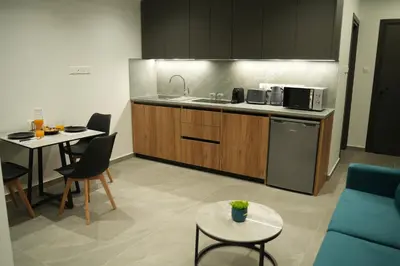 a kitchen with a sink and a table with chairs at Zen City Suites in Larnaka