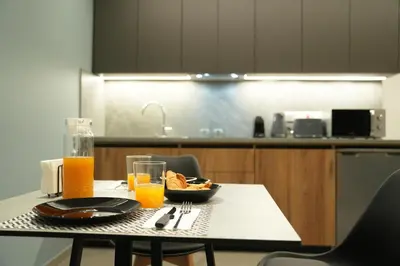 a table with a bowl of food and glasses of orange juice at Zen City Suites in Larnaka