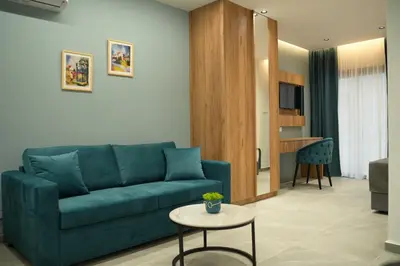a living room with a blue couch and a table at Zen City Suites in Larnaka