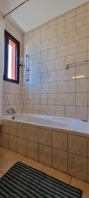a bath tub in a bathroom with a window at The Cozy Home Stay in Larnaca in Larnaka