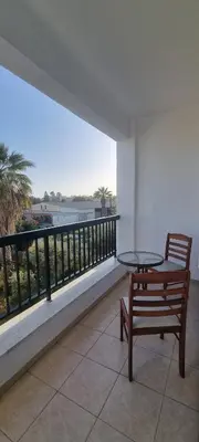 a bench sitting on a balcony with a view of the ocean at The Cozy Home Stay in Larnaca in Larnaka