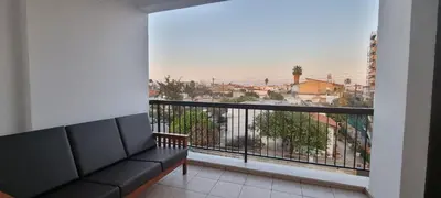 a balcony with a couch and a view of a city at The Cozy Home Stay in Larnaca in Larnaka