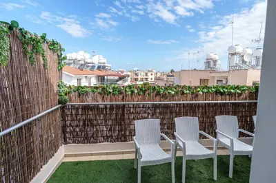 a balcony with three chairs and a fence at Mythical Sands Resort and Spa in Paralimni