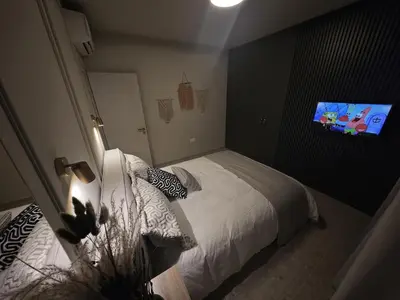 a bedroom with a bed with a tv on the wall at Ficus Suite 001 in Voroklini