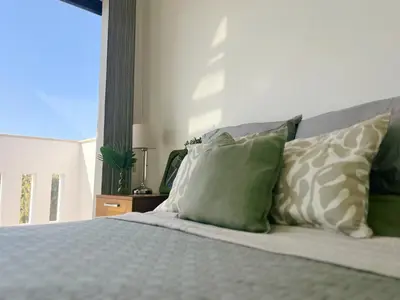 a bedroom with a bed with green and white pillows at Villa Aris in Ayios Theodhoros