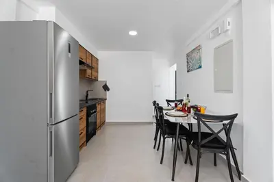 a kitchen with a table with chairs and a refrigerator at PANATHEON - Luxury 1 & 2 bdr bungalows 300 meters from sandy beach! in Ayia Napa