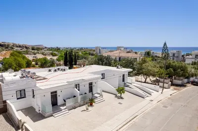 an aerial view of a white building with a swimming pool at PANATHEON - Luxury 1 & 2 bdr bungalows 300 meters from sandy beach! in Ayia Napa