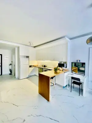a kitchen with white cabinets and a wooden table at Caesar Resort Apartments Marcellus 51 in Iskele