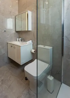 a bathroom with a toilet and a sink and a shower at Pantio Living Residence in Meneou