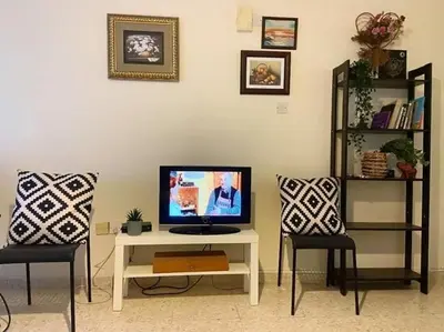 a living room with a tv and two chairs at Holiday home in Kapparis in Paralimni
