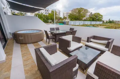 a rooftop patio with a hot tub and tables and chairs at Pernera One Suites in Pernera Protaras in Paralimni