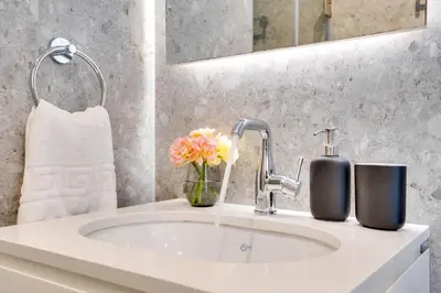 a bathroom with a sink with flowers and a mirror at Sea View Central Deluxe GAIA 302 in Larnaka