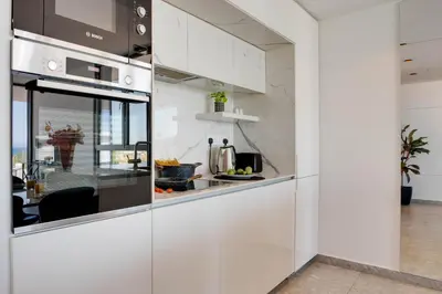 a kitchen with white cabinets and a counter at Sea View Central Deluxe GAIA 302 in Larnaka