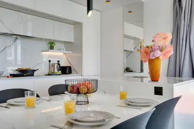 a dining room with a table with a vase of flowers at Sea View Central Deluxe GAIA 302 in Larnaka