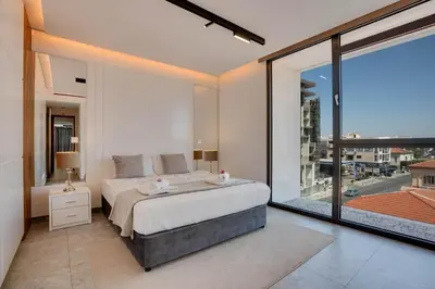 a bedroom with a bed and a large window at Sea View Central Deluxe GAIA 302 in Larnaka