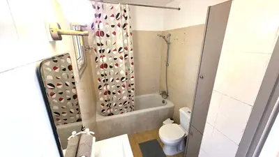 a bathroom with a tub and a toilet and a shower at Stylish 2BR Apartment with Balcony, Wifi & Pool in Larnaka