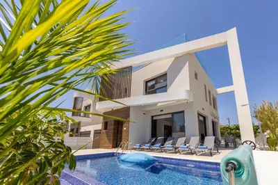 a villa with a swimming pool in front of a house at Villa Nissi 1 in Ayia Napa