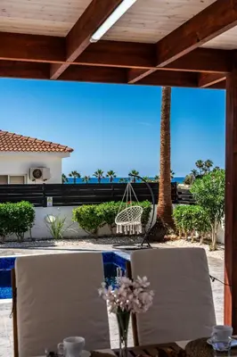 a table with two chairs and a swing on a patio at Casa Giovanni By Ezoria Villas in Ayia Napa