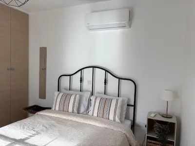 a white bedroom with a bed with white pillows at Cozy Central Stay with City Views in Nicosia