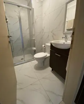 a bathroom with a shower and a toilet and a sink at Cozy Central Stay with City Views in Nicosia