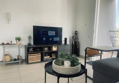 a living room with a tv and a table and chairs at Cozy Central Stay with City Views in Nicosia