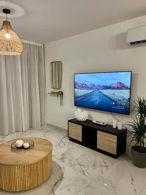 a living room with a flat screen tv on a wall at FatCow Beach Apartment Ultra in Larnaka