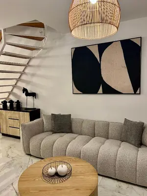 a living room with a couch and a table at FatCow Beach Apartment Ultra in Larnaka