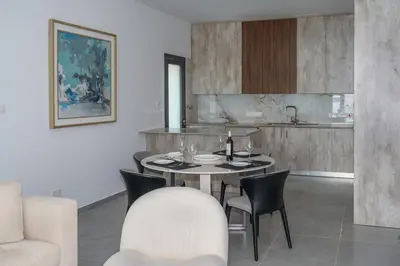 a dining room with a table and chairs and a kitchen at Kalamon Luxury Suite 203 w Pool and Gym in Livadhia
