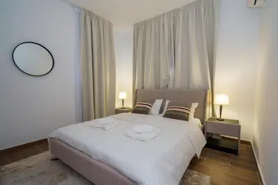 a bedroom with a large white bed and two lamps at Kalamon Luxury Suite 203 w Pool and Gym in Livadhia