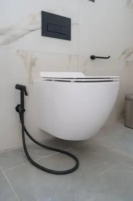 a white toilet with a hose attached to a wall at Kalamon Luxury Suite 203 w Pool and Gym in Livadhia